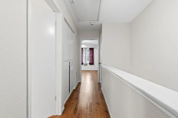 a view of an empty room with wooden floor
