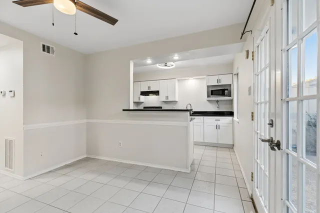 a kitchen with white cabinets and white appliances