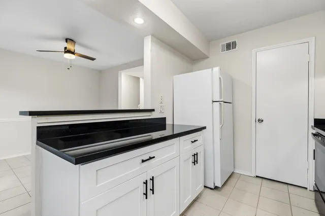 a kitchen with white cabinets and appliances