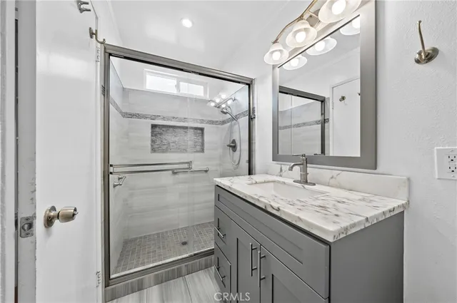 a bathroom with a granite countertop sink mirror and shower