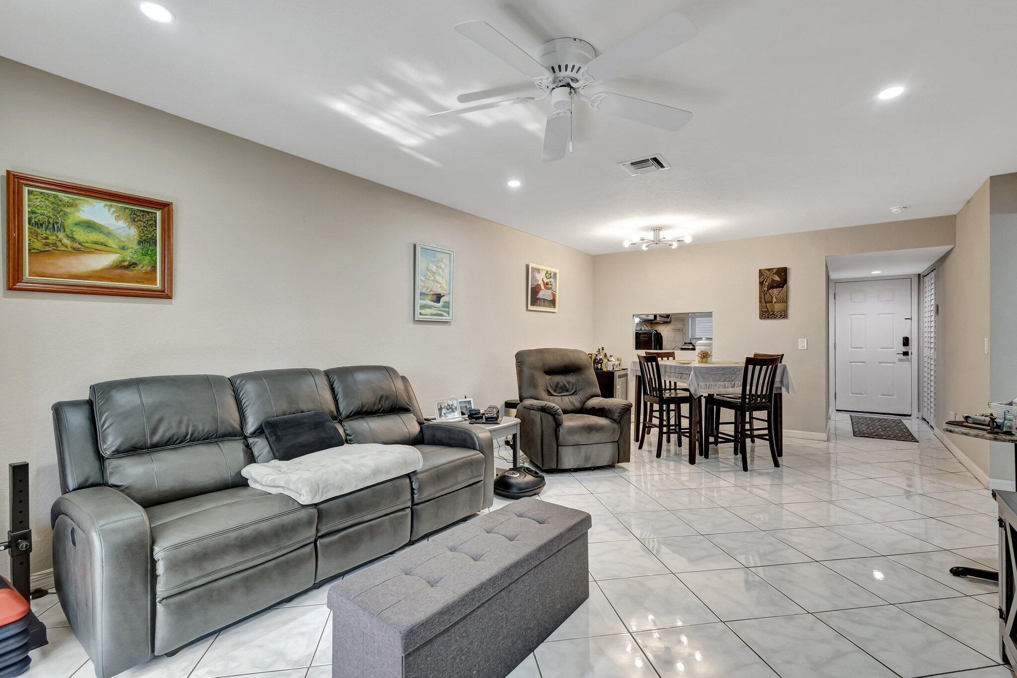 12012 Greenway Circle South, Unit 205 Royal Palm Beach, FL 33411 - Photo 22 of 36 a living room with furniture and a dining table with projector