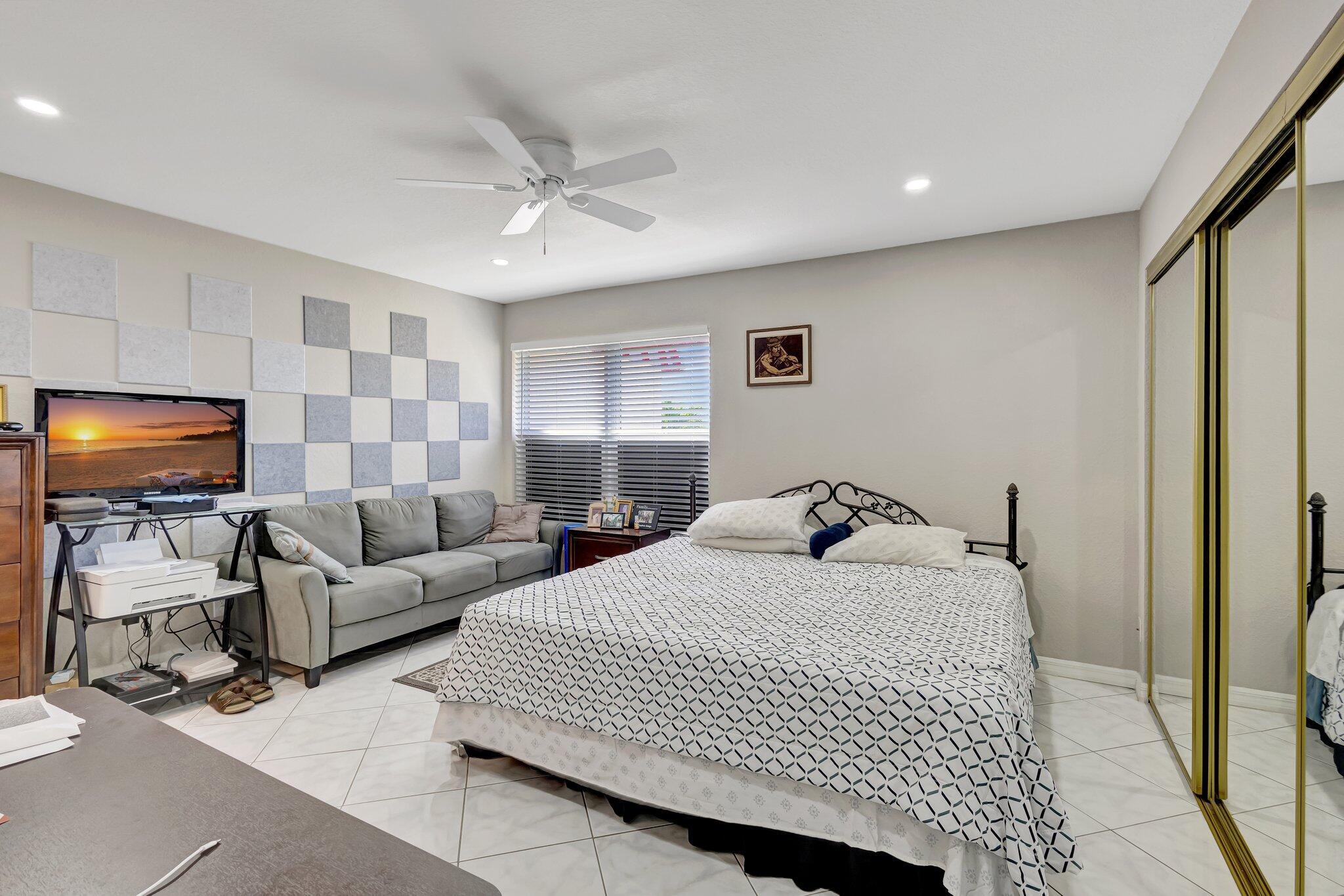 12012 Greenway Circle South, Unit 205 Royal Palm Beach, FL 33411 - Photo 25 of 36 a bedroom with a bed and a flat screen tv