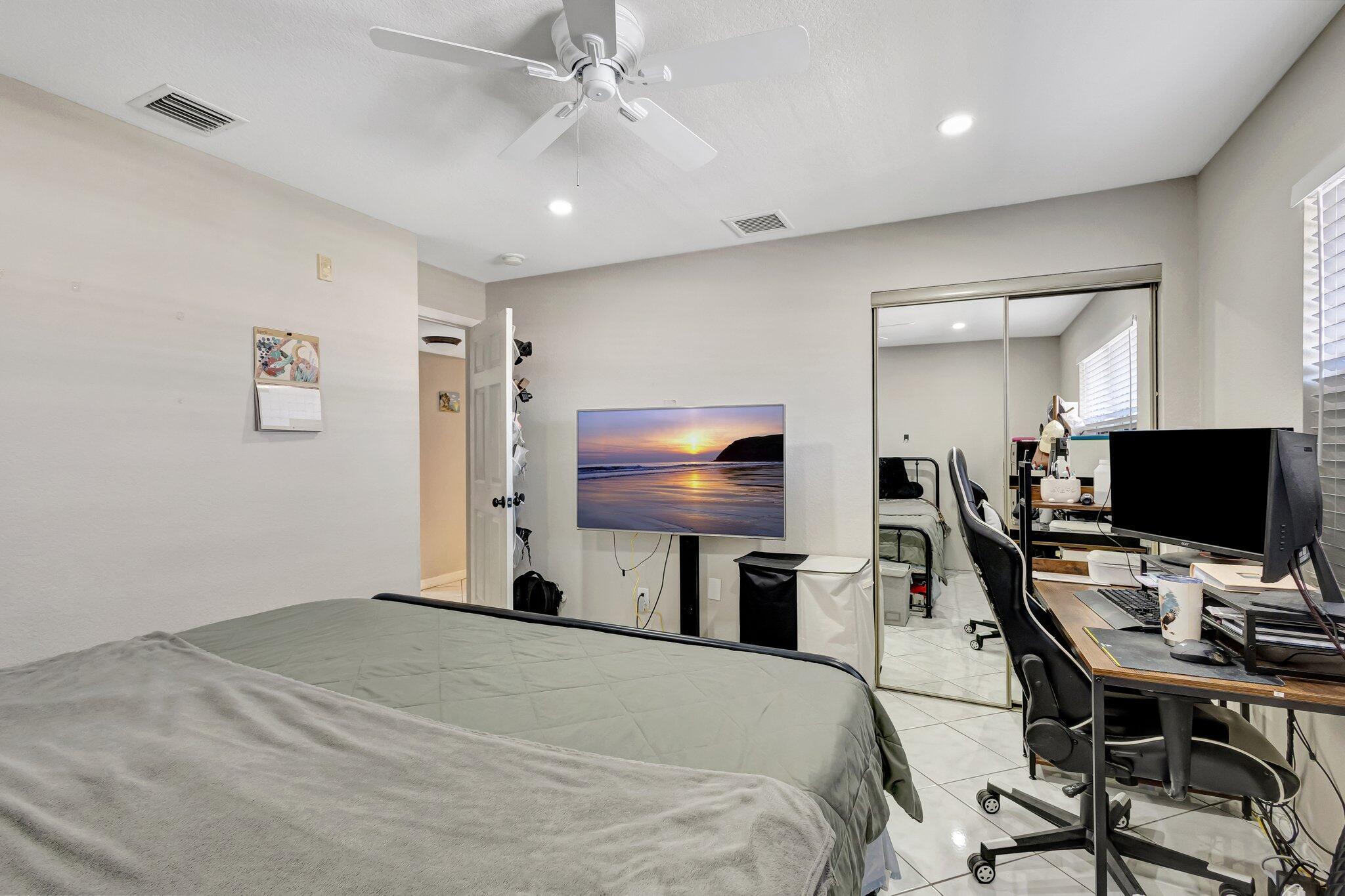 12012 Greenway Circle South, Unit 205 Royal Palm Beach, FL 33411 - Photo 32 of 36 a bedroom with a bed and a flat screen tv