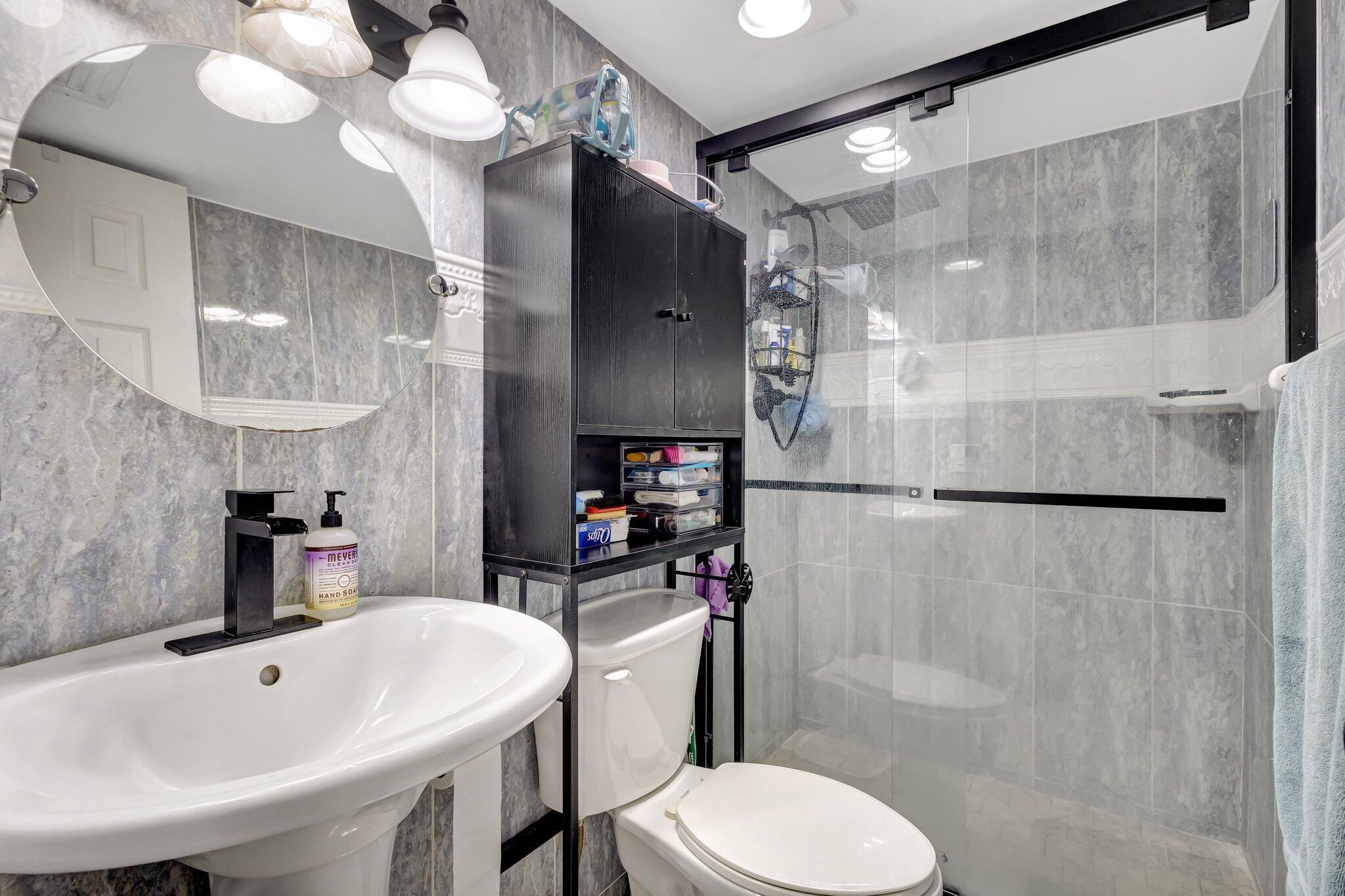 12012 Greenway Circle South, Unit 205 Royal Palm Beach, FL 33411 - Photo 33 of 36 a bathroom with a sink toilet and shower