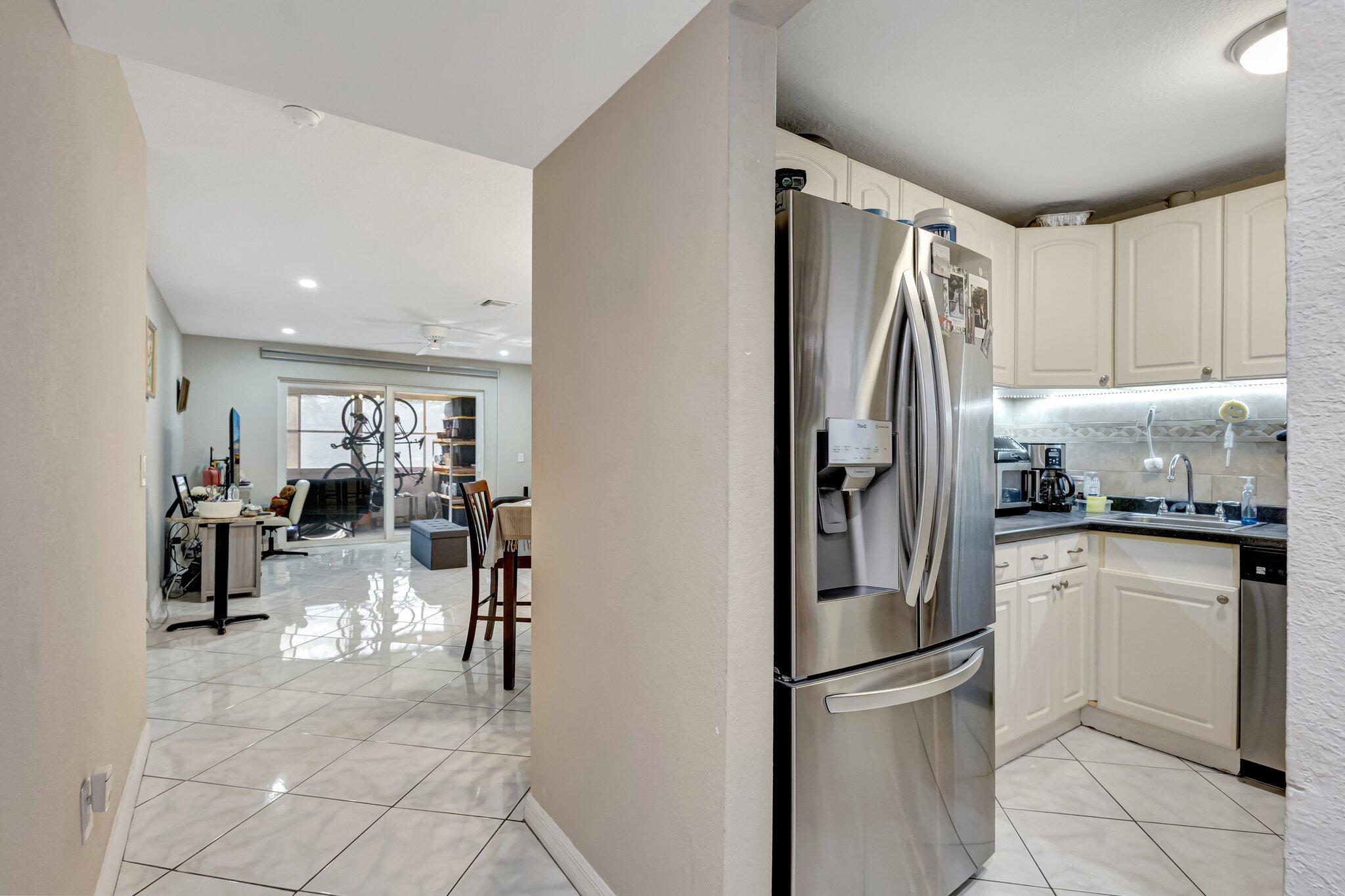 12012 Greenway Circle South, Unit 205 Royal Palm Beach, FL 33411 - Photo 9 of 36 a kitchen with stainless steel appliances granite countertop a refrigerator and a sink