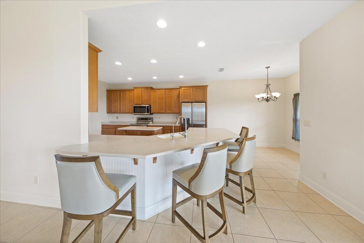 2940 Pomello Road Malabar, FL 32950 - Photo 10 of 42 a kitchen with a dining table chairs and refrigerator
