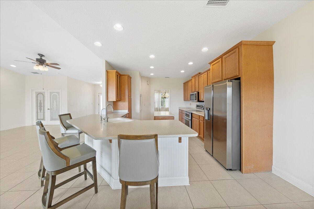 2940 Pomello Road Malabar, FL 32950 - Photo 11 of 42 a kitchen with stainless steel appliances kitchen island granite countertop a refrigerator and a stove top oven