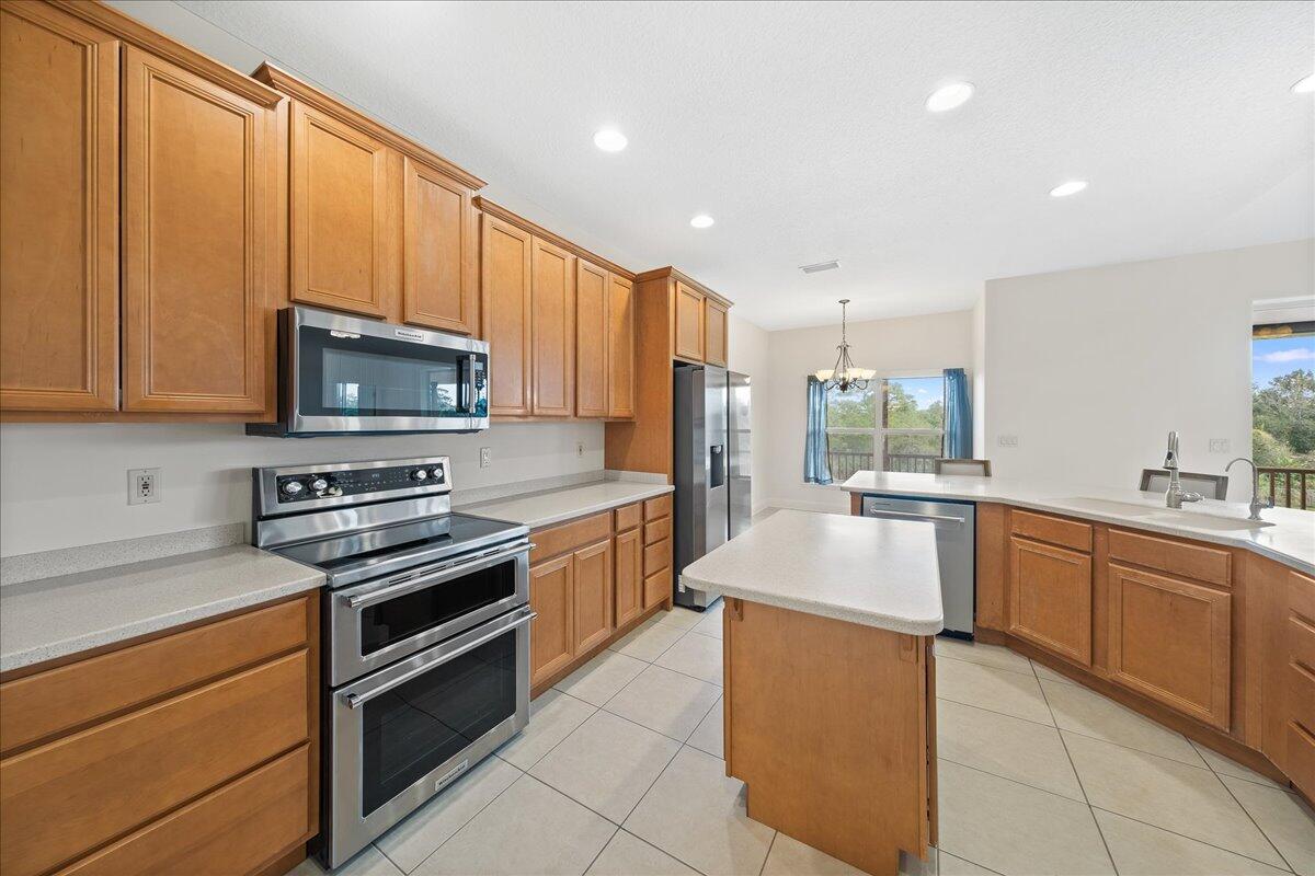 2940 Pomello Road Malabar, FL 32950 - Photo 12 of 42 a large kitchen with stainless steel appliances granite countertop a stove a sink and a microwave
