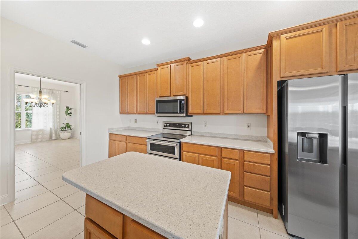 2940 Pomello Road Malabar, FL 32950 - Photo 13 of 42 a kitchen with stainless steel appliances granite countertop a refrigerator a stove and a sink with wooden floor