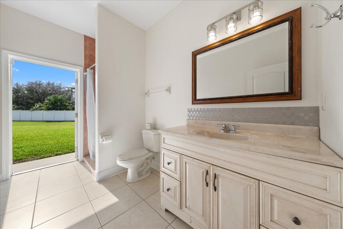 2940 Pomello Road Malabar, FL 32950 - Photo 31 of 42 a bathroom with a toilet a sink a mirror and window