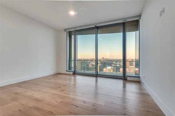an empty room with wooden floor and sliding glass door