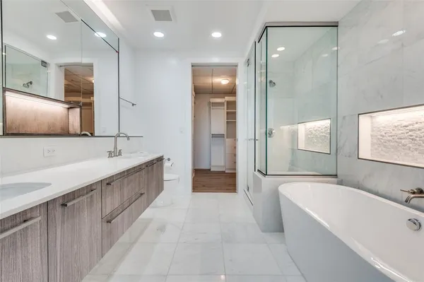 a bathroom with a bathtub a sink a mirror and a shower