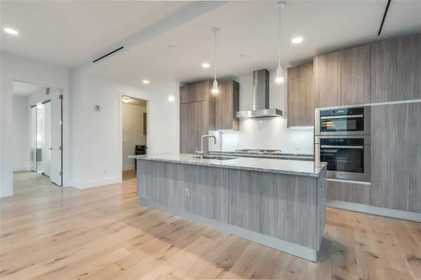 a large kitchen with kitchen island a sink stainless steel appliances and cabinets