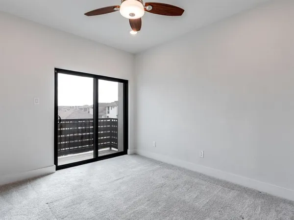 an empty room with chandelier fan