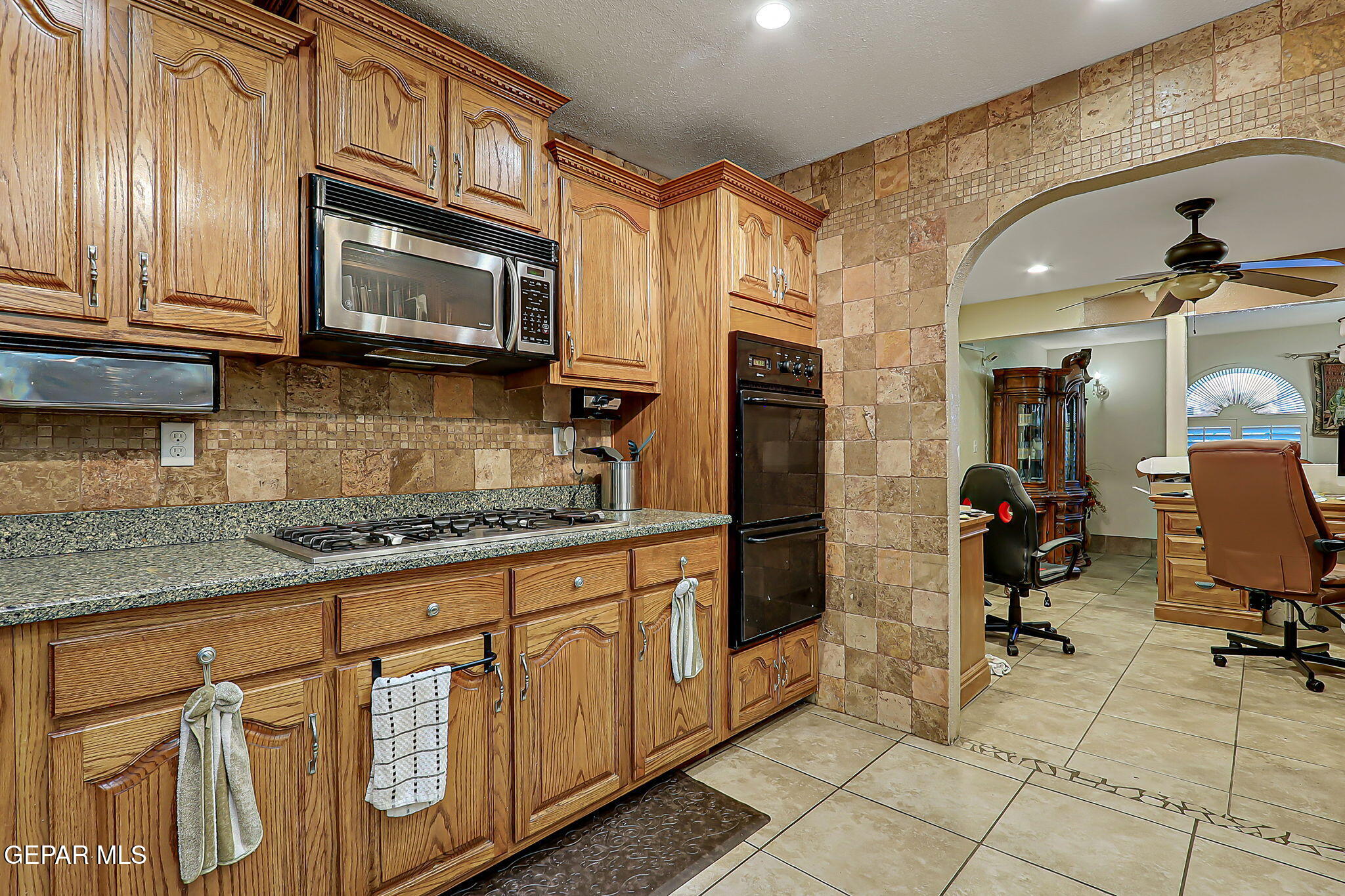 14800 Kingston Road Horizon City, TX 79928 - Photo 28 of 82 a kitchen with stainless steel appliances granite countertop a stove a sink and a microwave