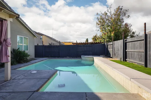 a view of a backyard with potted plants and wooden fence