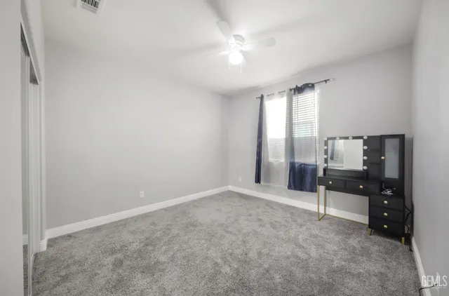an empty room with windows and cabinet