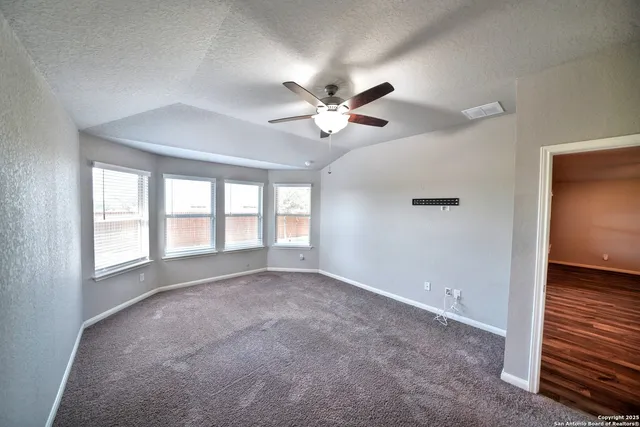 a view of an empty room with a ceiling fan