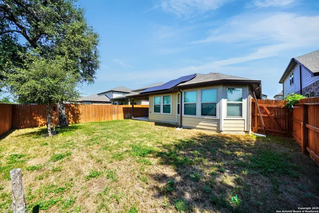 a view of backyard with wooden fence