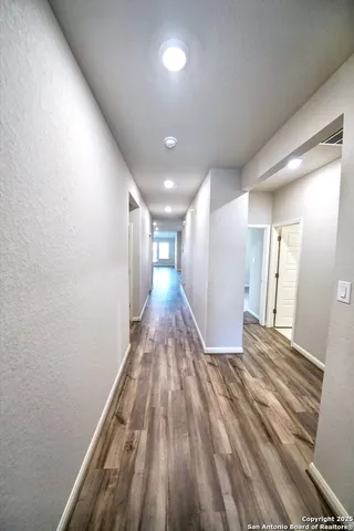 a view of a hallway with wooden floor