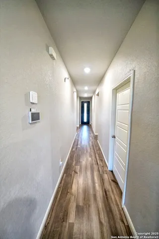 a view of a hallway with wooden floor