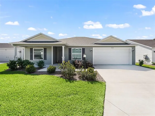 a front view of a house with a garden and yard