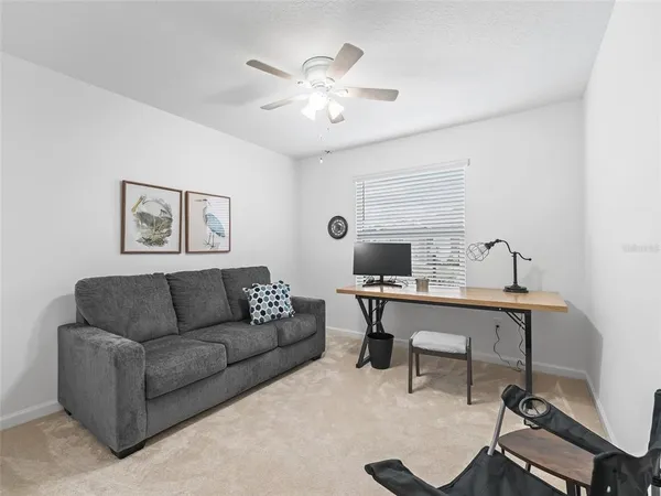 a living room with furniture a chandelier and a window