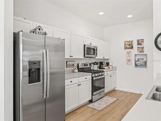 a kitchen with stainless steel appliances a refrigerator sink and microwave