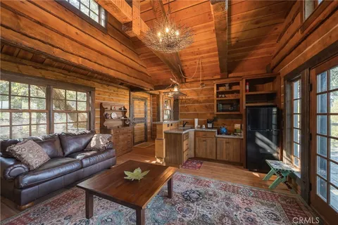 a living room with furniture a flat screen tv and kitchen view