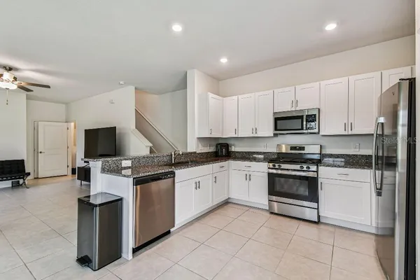 a kitchen with white cabinets stainless steel appliances and a sink