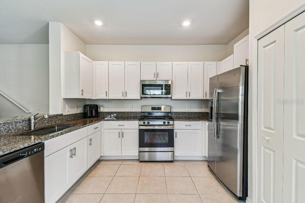 8331 Corner Pine Way New Port Richey, FL 34655 - Photo 21 of 41 a kitchen with granite countertop white cabinets and stainless steel appliances