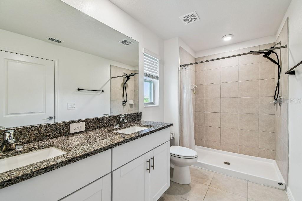 8331 Corner Pine Way New Port Richey, FL 34655 - Photo 35 of 41 a bathroom with a granite countertop sink a toilet and shower