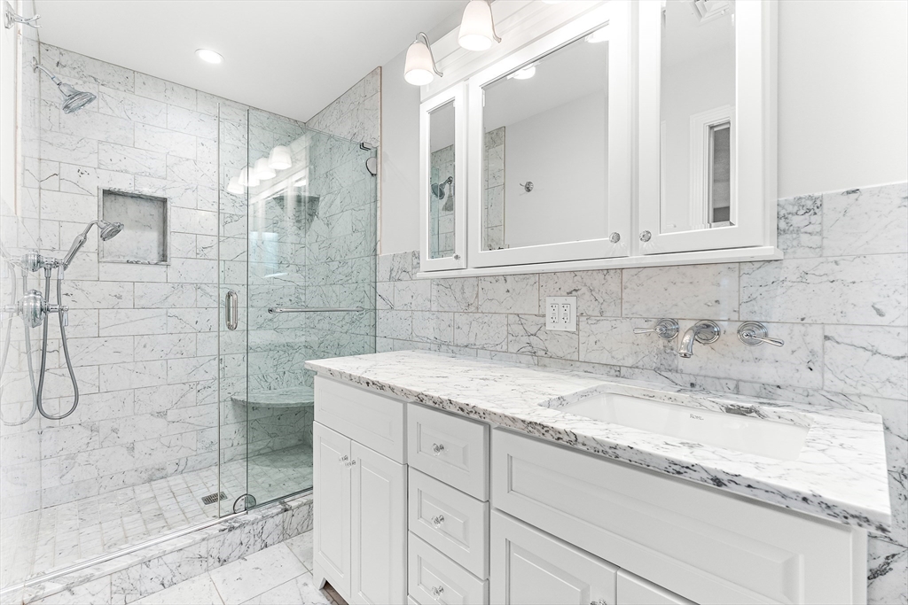 10 Viking Road Winchester, MA 01890 - Photo 25 of 42 a bathroom with a granite countertop sink mirror and shower