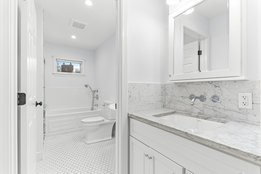 10 Viking Road Winchester, MA 01890 - Photo 29 of 42 a bathroom with a granite countertop sink toilet and shower