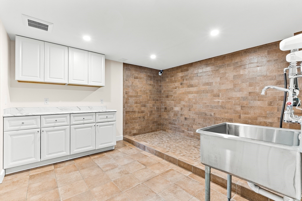 10 Viking Road Winchester, MA 01890 - Photo 32 of 42 a bathroom with a granite countertop sink a toilet and bathtub