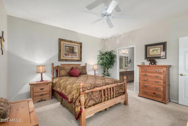 a bedroom with a bed a chandelier and a dresser