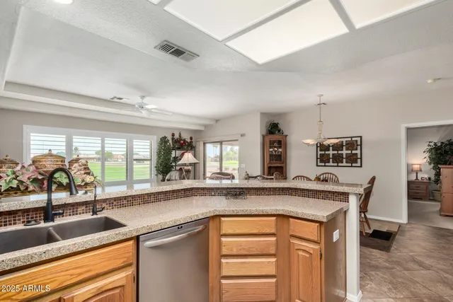 a kitchen with granite countertop a sink and a refrigerator