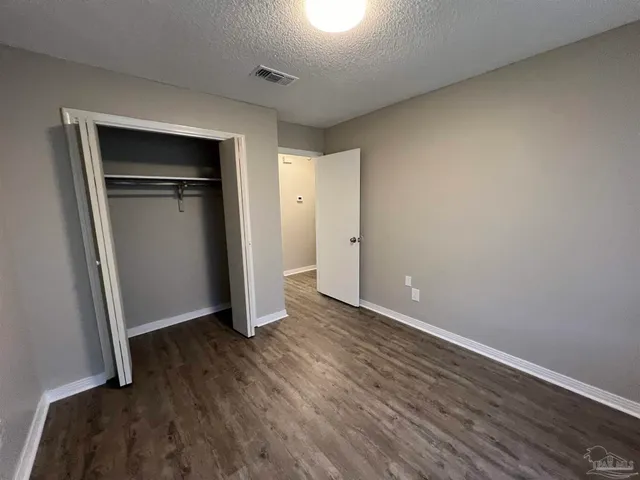 an empty room with wooden floor and closet