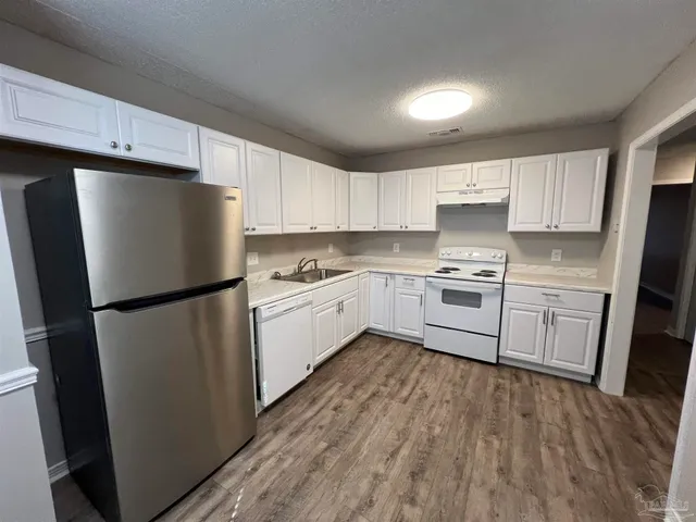 a kitchen with white cabinets and white stainless steel appliances