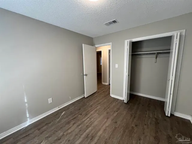 an empty room with wooden floor and closet