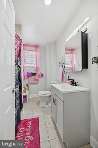 a bathroom with a sink vanity mirror and toilet