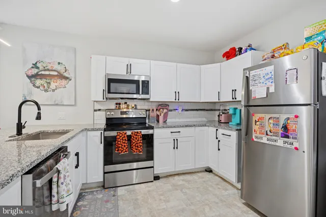 a kitchen with stainless steel appliances granite countertop a stove top oven a sink and dishwasher