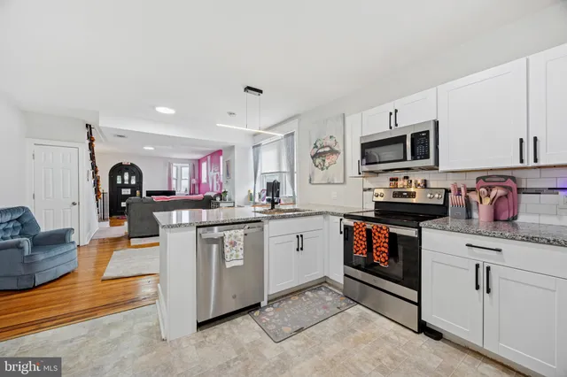 a kitchen with granite countertop a sink and white appliances