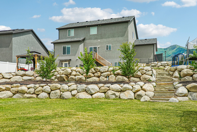 203 North 1900th Street West Mapleton, UT 84664 - Photo 39 of 48 Expansive backyard featuring a manicured lawn and multi-tiered rock retaining walls