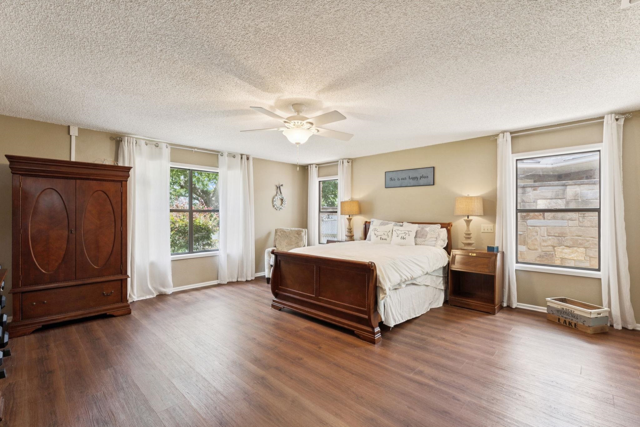 180 Wampum Way Seguin, TX 78155 - Photo 11 of 24 a spacious bedroom with a bed and a dresser with wooden floor