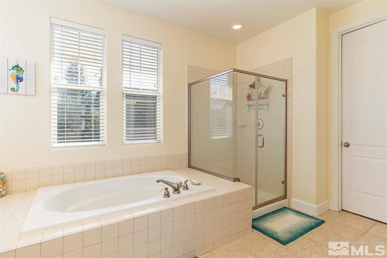 1644 Sawtooth Trail Reno, NV 89523 - Photo 11 of 15 a bathroom with a tub a potted plant and a shower
