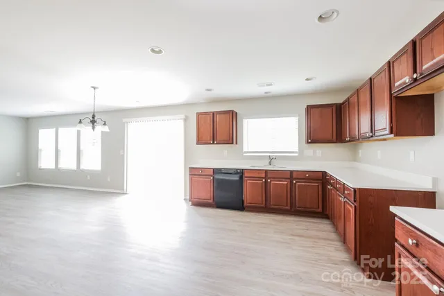 a large kitchen with stainless steel appliances granite countertop a large stove a sink dishwasher and a microwave oven with large wooden cabinets