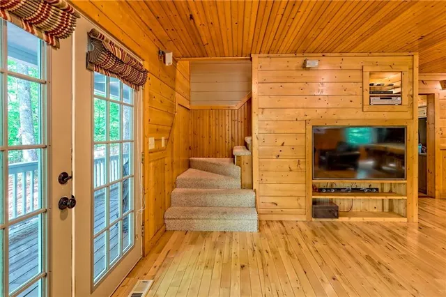 a view of a patio with table and chairs with wooden floor and fence