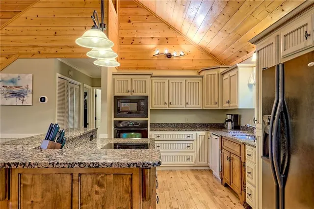 a view of front of a house with large trees and plants