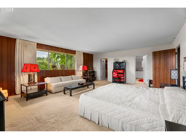 a bedroom with furniture and a large window